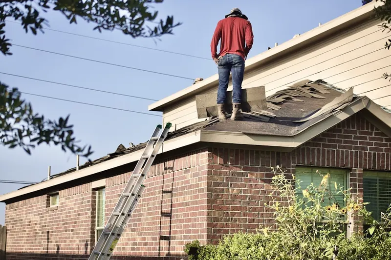 Professional roofer working on a residential roof in Toledo